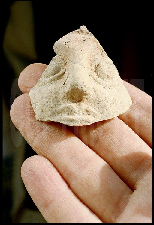 Ce fragment de céramique, découvert dans la tombe funéraire I, représente un visage d'homme.