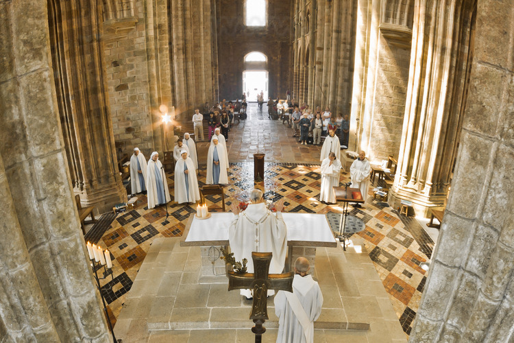 In the choir of the abbey church, monks and nuns during the noon mass.