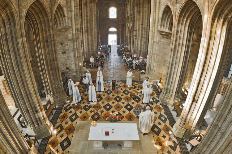 In the choir of the abbey church, monks and nuns during the noon mass.