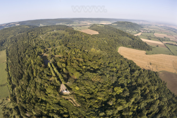 Peak of Eparges, aerial view. Top right, the village of Eparges. Bottom center, the monument of the Point X, at the foot of which stumbled French troops throughout the war, until the arrival of American troops in 1918. The former front line is now indicated by a paved road, visible at left center (left of the road, the German lines, right, the French lines). On the north side of the monument, it is reminded the sacrifice of  