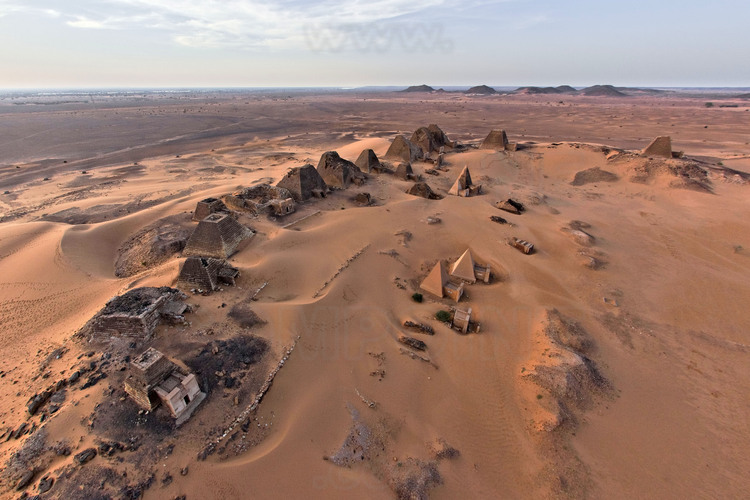 A few kilometers east of the Nile, in the middle of a desert plain, rise strange pyramids, with steep edges. Here, in Meroe, in the heart of Sudan, which were buried the kings of the first known civilization of black Africa. At that time, a rich city extends to the river, with religious monuments, shops, crafts (metalworking, jewelry, pottery ..) while the royal cemetery is located at a distance on hills in the desert. At dusk, general view of the royal tombs in the cemetery north, by far the largest and best preserved. On the horizon, the green bar of the Nile and cultures.