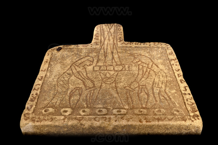 Trouvée sur les sites de fouilles archéologiques de Méroé, cette table d'offrandes en grès représente une déesse et le dieu Anubis. Sur le pourtour, une inscription en écriture cursive méroïtique.