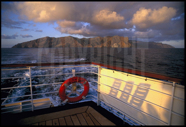 Embarquement sur le RMS St. Helena, (vaisseau des postes britanniques) pour la prochaine escale à cinq jours de mer : Le Cap, en Afrique du Sud. En arrière plan, la côte sud de l'île.