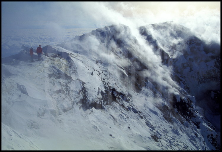 Au sommet de l'Erebus, soleil et vapeurs volcaniques jouent, enveloppant les abords du cratère sous un voile de fin du monde.