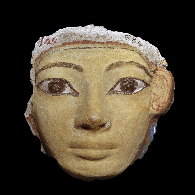 Ce petit visage (12 cm de diamètre) de femme nubienne est en plâtre peint. Les masques en plâtre peint ont commencé à apparaître pendant la XVIIIème dynastie du Nouvel Empire. La couleur jaunâtre de la peau est traditionnel pour nous signifier qu'il s'agit du visage d'une femme.