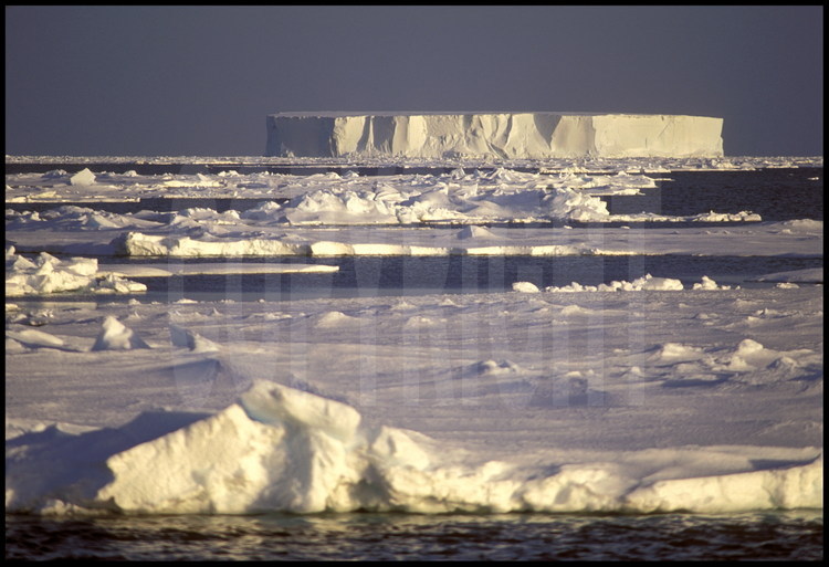 Au cours de la remontée vers le nord, paysage de débâcle antarctique, avec un iceberg caractéristique de l'hémisphère sud en arrière plan.