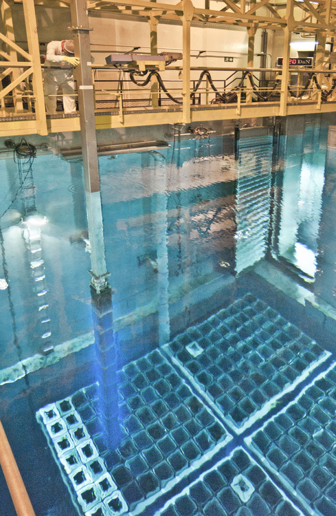 Centrale nucléaire de Cattenom (archives, 2003) : Dans le bâtiment combustible 4, vue générale de la piscine de stockage des assemblages, où un technicien d'EDF procède au déchargement de barres de combustibles provenant du réacteur. Les barres de combustible émettent une étrange lumière bleutée (l’effet Cherenkov), dues aux émissions radio-actives au contact de l'eau. C'est à l'équivalent de cet endroit que, par manque d'eau, l'échauffement du combustible a provoqué l'incident majeur de la centrale de Fukushima.