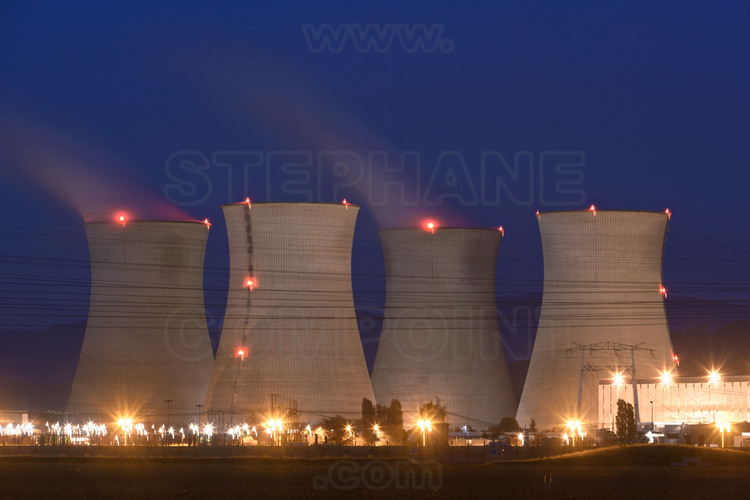 Centrale nucléaire du Bugey : Vue nocturne des installations depuis le sud ouest. Des quatre tours aéroréfrigérantes (hauteur 128 m., largeur 104 m.), celle qui n'émettent pas de panache de vapeur correspondent au réacteur n° 4, à l'arrêt pour sa révision décennale.