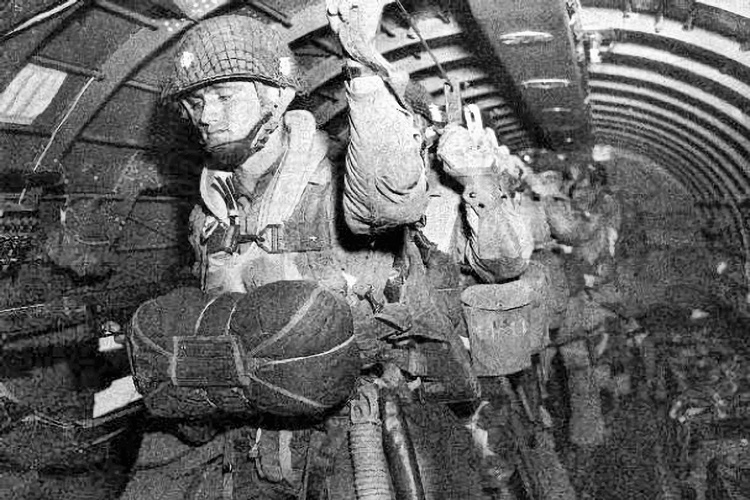 Normandie - Manche (50) - Sainte Mère Eglise : Site 6 : Sainte Mere Eglise. Le 5 juin 1944 a 23 heures, les forces alliees americaines sont parachutees au-dessus de Sainte-Mere-Eglise lors de l'operation Overlord. 15 000 hommes sont largues sur le village et ses environs, majoritairement issus de la 82e division aeroportee US (82nd Airborne), ainsi que de nombreux parachutistes de la 101e division aeroportee du fait d'erreurs de largage. Les Allemands tirent sur les parachutistes qui s'abattent sur le sol. John Steele, l'un d'eux, fut atteint au pied par une balle, ne pu controler son parachute et atterrit finalement sur le clocher de l'eglise vers 4h00 du matin. Il tenta de se liberer de son parachute tandis que sur la place, tout autour de l'eglise, la bataille faisait rage. Il prit alors la decision de faire le mort afin d'eviter de servir de cible a l'ennemi. Apres plus de deux heures, un soldat allemand vint le decrocher. Steele fut soigne et fait prisonnier, s'evada trois jours apres, rejoignit les lignes alliees et fut transfere vers un hopital en Angleterre. Depuis, un mannequin est accroche sur l'eglise de Sainte-Mere-Eglise en son hommage. John Steele est revenu plusieurs fois en Normandie pour les commemorations. Il est decede en 1969. Sainte-Mere-Eglise fut la premiere ville de France liberee par les airs. Photos d'archives non disponible a la vente sur ce site mais uniquement presente pour situer le contexte historique. // France - Normandy - Manche (50) - Sainte Mère Eglise: Site 6: Sainte Mere Eglise. On June 5, 1944 at 11 p.m., the American allied forces parachuted above Sainte-Mere-Eglise during Operation Overlord. 15,000 men were dropped on the village and its surroundings, mainly from the US 82nd Airborne Division, as well as numerous paratroopers from the 101st Airborne Division due to drop errors. The Germans shoot at the paratroopers who fall to the ground. John Steele, one of them, was hit in the foot by a bullet, could not control his parac