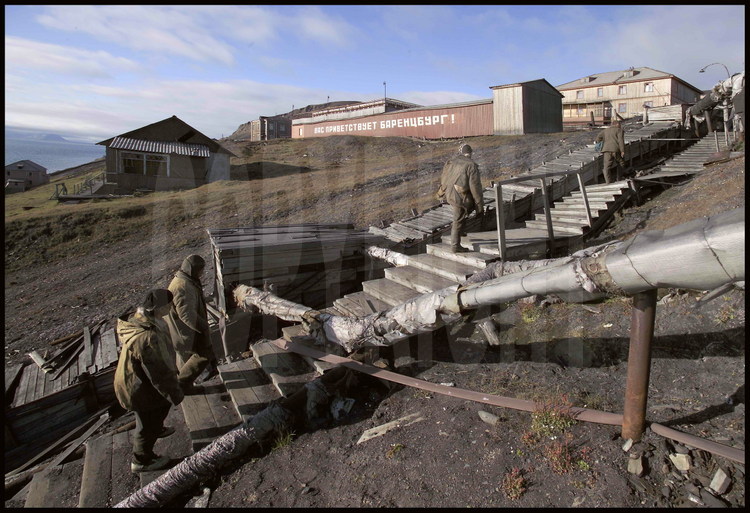 Baraquements abandonnés aux carreaux cassés, conduites d’eau sur pilotis, débris de ferrailles rouillées, wagonnets de minerais suspendus sur leurs câbles, routes défoncées par le gel, le décor du centre-ville de Barentsburg est particulièrement saisissant.