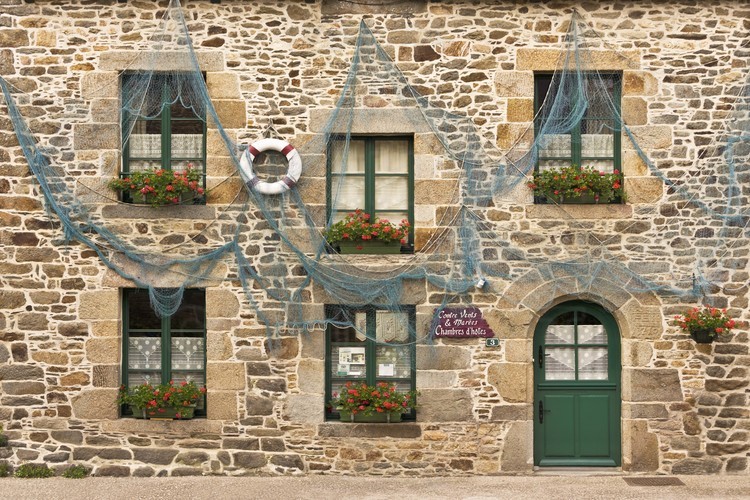 Ille et Vilaine (35) - Saint Suliac, classé parmi les plus beaux villages de France : Vue du village depuis le nord est. Au premier plan au centre, la rue de la Grande Cohue et l'eglise Saint Suliac. En arriere plan, la Rance. Belvedere sur l'estuaire de la Rance, Saint-Suliac est longtemps reste un village de terre-neuvas. Dans les ruelles, les fleurs poussent entre les pierres de granit de magnifiques maisons. Moulin a maree, anciennes salines, menhir font partie des richesses locales que l'on peut admirer dans un site remarquablement preservé. // France - Ille et Vilaine (35) - Saint Suliac, classified among the most beautiful villages in France: View of the village from the north east. In the foreground in the center, the rue de la Grande Cohue and the Saint Suliac church. In the background, the Rance. Belvedere on the estuary of the Rance, Saint-Suliac has long been a village of Newfoundlanders. In the alleys, flowers grow between the granite stones of magnificent houses. Tide mill, ancient saltworks, menhir are some of the local treasures that can be admired in a remarkably preserved site.