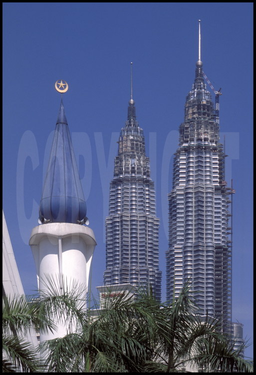 Les Petronas Towers vues depuis le Sud-Ouest. Au premier plan, le minaret de l'une des nombreuses mosquées de la ville, où l'islam est religion d'état.
