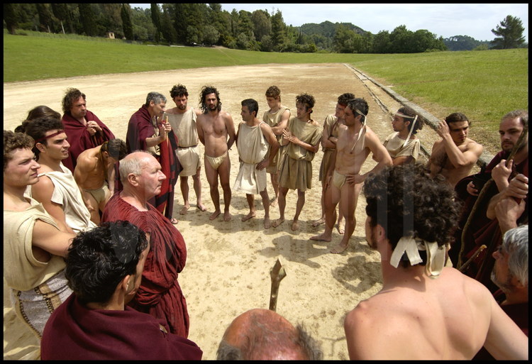 Au milieu du stade antique d’Olympie, les hellanodices détaillent aux athlètes le règlement des épreuves telles qu’elles se déroulaient dans l’Antiquité.