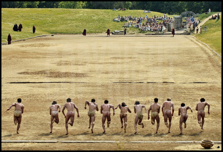 La course du stadion (192m) était l’épreuve reine des jeux antiques. Le départ, qui se faisait sans starting-block nécessite un entraînement spécifique pour les athlètes d’aujourd’hui. Comme à l’époque antique, les athlètes s’élancent face au sanctuaire d’Olympie et au temple de Zeus.