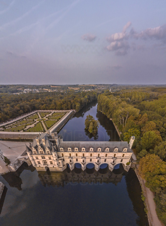 Val de Loire - Indre et Loire (37) - Château de Chenonceau : Vue aérienne depuis l'ouest, au soleil couchant. Au premier plan et au centre, le Cher. A gauche, l'avant-cour, la tour des Marques et le jardin de Diane de Poitiers. En arrière plan à gauche, les coteaux du village de Chenonceaux. Bâti sur les plans d’un palais vénitien au XVIe siècle, le château de Chenonceau, doté de cinq arches enjambant élégamment le Cher, est l’unique château-pont au monde. Surnommé le château des Dames, son histoire a été marquée, entre autres, par celle de cinq femmes, grandes séductrices ou femmes de pouvoir : Diane de Poitiers (1499 - 1566), Catherine de Médicis (1519 - 1589), Louise de Lorraine (1553 - 1601), Gabrielle d’Estrées (1573 - 1599) et Louise Dupin (1706 - 1799). // France - Loire valley - Indre et Loire (37)  - Castle of Chenonceau : Aerial view from the west, at sunset. On foreground and in center, the Cher. On left, the forecourt and the garden of Diane de Poitiers. Built on the plans of a Venetian palace in the sixteenth century, Chenonceau Castle, with five arches spanning the Cher River, is the only bridge-castle in the world. Nicknamed the Ladies' Castle, its history has been marked, among others, by five women, great seductresses or women of power: Diane de Poitiers (1499 - 1566), Catherine de Medici (1519 - 1589), Louise de Lorraine ( 1553 - 1601), Gabrielle d'Estrées (1573 - 1599) and Louise Dupin (1706 - 1799).