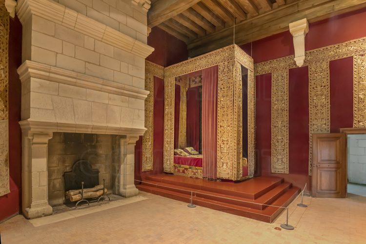 Val de Loire - Loir et Cher (41) - Château de Chambord : Appartements de François 1er. En 1541, le roi décide de transférer son logis du donjon et de l'installer dans l'aile est. Le logis royal se compose d'une chambre, d'une garde robe, d'un cabinet, d'une salle de conseil et d'un oratoire. A l'image de son occupant, voyageur infatigable, le mobilier est démontable et facile à transporter : lorsqu'il vient à Chambord, le château est meublé provisoirement. A  droite, le lit royal, de velours rouge.  Aux murs, des broderies en or vénitiennes du XVIème siècle. Ce serait dans cette chambre que le souverain aurait gravé sa célèbre maxime : 