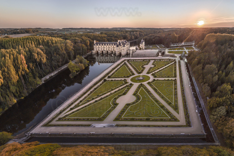 Val de Loire - Indre et Loire (37) - Château de Chenonceau : Vue aérienne depuis le nord-est, au soleil couchant. A gauche, le Cher. Au premier plan, le jardin de Diane de Poitiers. Au second plan, la tour des Marques, l'avant-cour et le jardin de Catherine de Medicis. Bâti sur les plans d’un palais vénitien au XVIe siècle, le château de Chenonceau, doté de cinq arches enjambant élégamment le Cher, est l’unique château-pont au monde. Surnommé le château des Dames, son histoire a été marquée, entre autres, par celle de cinq femmes, grandes séductrices ou femmes de pouvoir : Diane de Poitiers (1499 - 1566), Catherine de Médicis (1519 - 1589), Louise de Lorraine (1553 - 1601), Gabrielle d’Estrées (1573 - 1599) et Louise Dupin (1706 - 1799).  // France - Loire valley - Indre et Loire (37)  - Castle of Chenonceau : Aerial view from the northeast, at sunset. On left, the Cher. On foreground, the garden of Diane de Poitiers. On background, the Marques Tower, the forecourt and the garden of Catherine de Medicis. Built on the plans of a Venetian palace in the sixteenth century, Chenonceau Castle, with five arches spanning the Cher River, is the only bridge-castle in the world. Nicknamed the Ladies' Castle, its history has been marked, among others, by five women, great seductresses or women of power: Diane de Poitiers (1499 - 1566), Catherine de Medici (1519 - 1589), Louise de Lorraine ( 1553 - 1601), Gabrielle d'Estrées (1573 - 1599) and Louise Dupin (1706 - 1799).