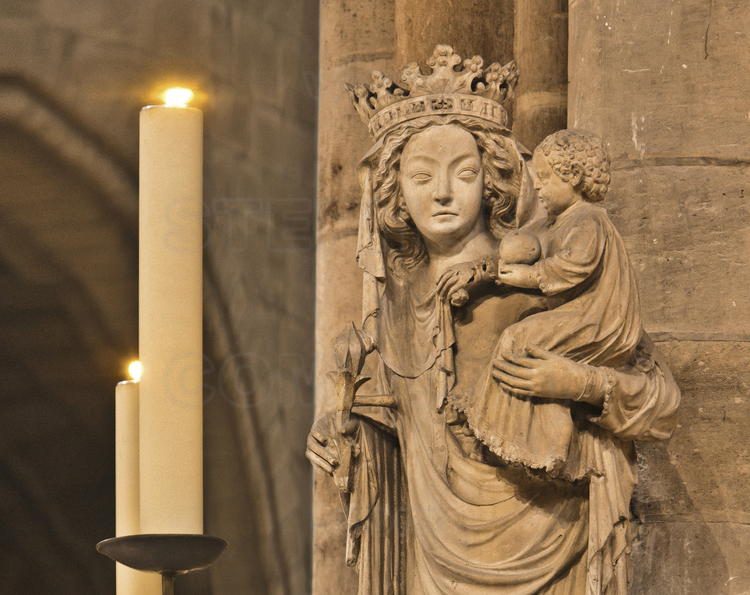 Paris (75) - Cathédrale Notre Dame de Paris : Au pied du pilier sud-est du transept central, la statue de Notre Dame de Paris. Elle est datee du XIVe siecle et provient de la chapelle Saint-Aignan, situee dans l'ancien cloitre des Chanoines de l'Ile de la Cite. Elle fut transferee a Notre-Dame en 1818 et placee d'abord au trumeau du Portail de la Vierge en remplacement de la Vierge du XIIIe siecle, mutilee en 1793. En 1855, Viollet-le-Duc la posa a son emplacement actuel. // France - Paris (75) - Cathedral Notre Dame de Paris : At the foot of the pillar southeast of central transept, the statue of Notre Dame de Paris. It is dated from the fourteenth century and comes from the chapel of Saint-Aignan, located in the former monastery of the Canons of the Ile de la Cite. It was transferred to Notre Dame in 1818 and placed first at the pier Portal of the Virgin in replacement of the Virgin of the thirteenth century, mutilated in 1793. In 1855, Viollet-le-Duc put it in its current location.
