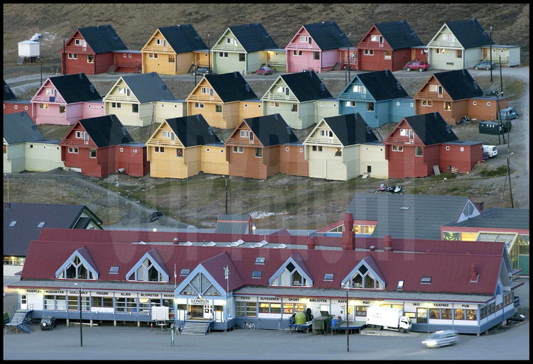 Aujourd’hui peuplée de 1600 habitants, parmi lesquels seulement 233 mineurs norvégiens, Longyearbyen est la ville principale de l’archipel. C’est aussi l’une des communautés humaines les plus septentrionales du globe, à deux heures de vol du continent. Même au cœur de la nuit polaire, elle y est reliée par une correspondance aérienne quotidienne. Propriétaires ou locataires, les habitants de ces maisons en bois ne peuvent pas en choisir la couleur, celle-ci étant imposée par la mairie pour égayer les rues de la ville.