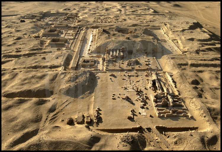 Vue depuis le même axe (Est) que l’image de synthèse n° 35, les vestiges du complexe funéraire et de la pyramide de Pépy 1er (VIème dynastie) aujourd’hui. Au premier plan, le temple funéraire. En arrière plan, les pyramides des reines.