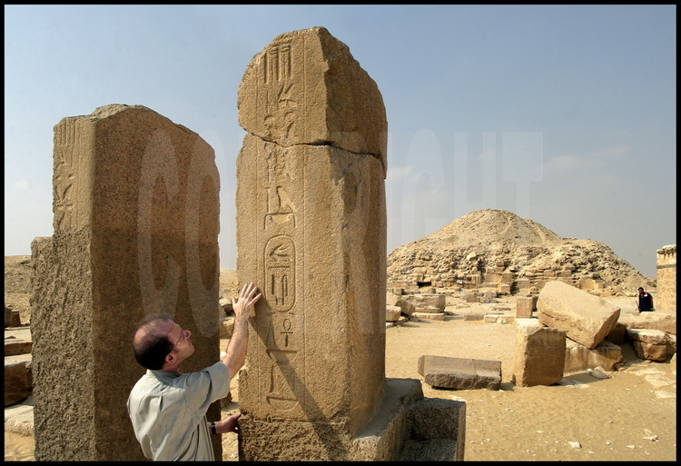 Le directeur de l’Institut Français d’Archéologie Orientale Bernard Mathieu nous indique les inscriptions hiéroglyphiques à l’entrée du complexe funéraire du pharaon Ounas. En arrière plan, la pyramide d’Ounas (Vème dynastie).