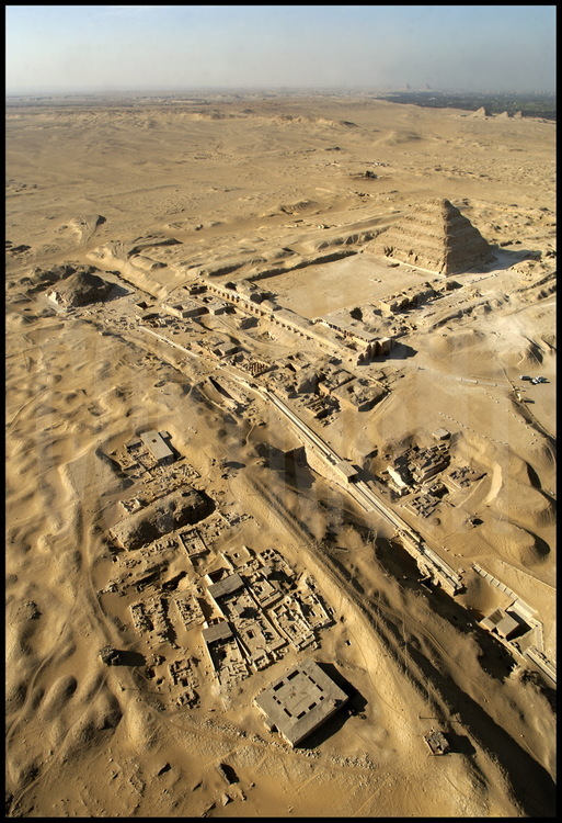 Vue aérienne de la nécropole de Sakkarah nord depuis le Sud-Est. Au premier plan, les vestiges du monastère de Saint Jérémie (à gauche) et la chaussée d’Ounas. Au second plan, la pyramide d’Ounas (Vème dynastie), et le complexe funéraire de Djoser (IIIème dynastie).