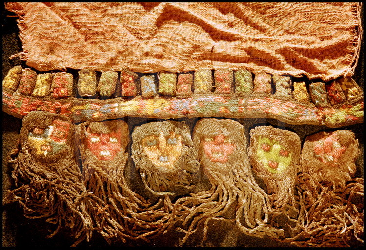 Futur musée de Nazca, ville de Nazca, Pérou.
Sur le bord de ce manteau funéraire datant du 4ème siècle après JC, un groupe de têtes-trophées (hauteur : 2 cm).