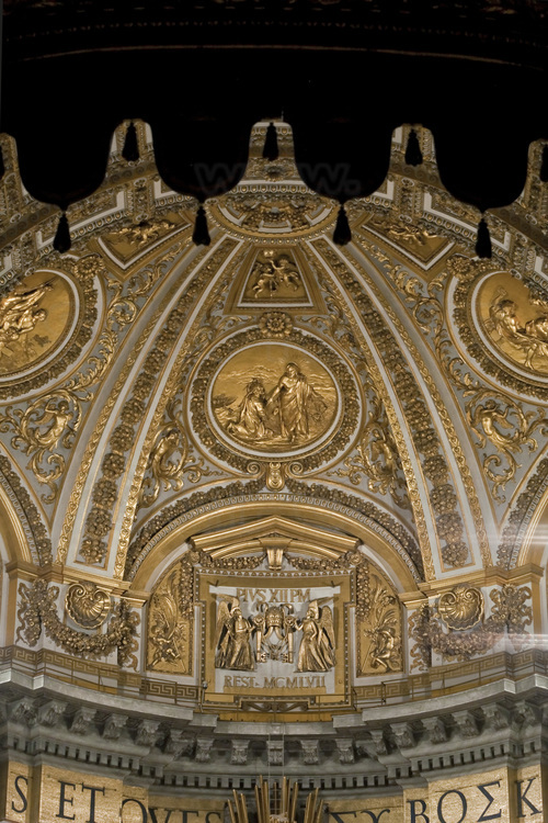 Italie - Rome - Vatican - Intérieur de la basilique Saint Pierre - Point photo 24 : Dans l'abside, la Gloria représente les cieux, en stuc doré, dans un style baroque affirmé  Le Bernin exécuta, entre 1656 et 1666, cette grande construction de bronze de vingt mètres de hauteur, abritant le siège, qui est la relique la plus vénérée des chrétiens. Cette œuvre revêt l'aspect d'un trône de bronze soutenu par quatre pères de l'Église. Il est couronné de putti (chérubins) et d'une gloire aux rayons qui entourent l'ouverture ovale d'albâtre, au centre de laquelle se voit la colombe, symbole du Saint Esprit et trait d'union entre le ciel et la terre. // Italy - Roma - Vatican - Interior of St. Peter's Basilica - Photo point 24 : In the apse, the Gloria represents the heavens, in gilded stucco, in a baroque style. Between 1656 and 1666, Bernini executed this large bronze construction of twenty meters in length. height, sheltering the seat, which is the most venerated relic of Christians. This work takes on the appearance of a bronze throne supported by four fathers of the Church. He is crowned with putti (cherubim) and a glory to the rays that surround the oval opening of alabaster, in the center of which is seen the dove, symbol of the Holy Spirit and hyphen between heaven and earth.