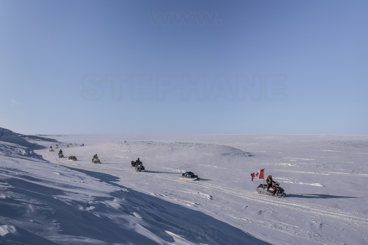 Canada - Etat du Nunavut - Opération Nunalivut 2018 - Environs de Cambridge Bay - Dirigée par le ranger Allan Elatiak, 70 ans, la patrouille de motoneiges se dirige vers l'emplacement prévu pour monter le camp de survie n° 1. En arrière plan, les plaines et lacs gelés de l'île Victoria. // Canada - State of Nunavut - Operation NUNALIVUT 2018 - Surroundings of Cambridge Bay - Led by Ranger Allan Elatiak, age 70, the snowmobile patrol is heading to the planned location to build No. 1 Survival Camp. In the background, the frozen plains and lakes of Victoria Island.