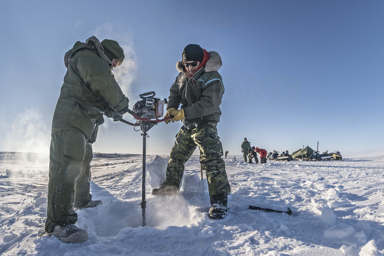 Canada - State of Nunavut - Operation NUNALIVUT 2018 - Surroundings of Cambridge Bay - Survival Camp # 1: Soldiers are initiated by the Rangers into ice fishing, which can save lives in polar isolation.