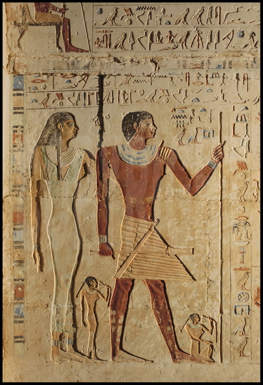 Détail du mur gauche de la façade colorée de Haou-Néfer. A gauche, Khouti, à droite Haou-Néfer, à leurs pieds, deux de leurs quatre filles. Celle qui est représentée debout a sans doute joué un rôle important dans la vie de son père.