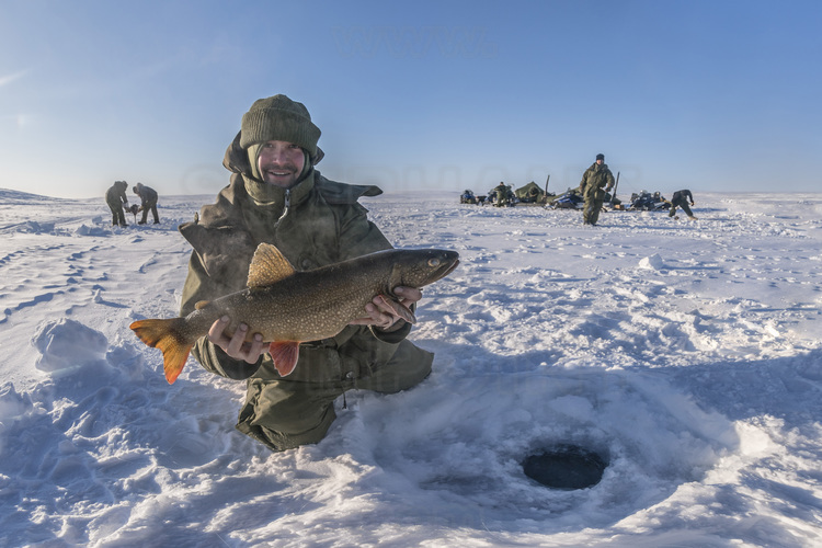 Canada - Etat du Nunavut - Opération Nunalivut 2018 - Environs de Cambridge Bay -  Camp de survie n° 1 : les militaires sont initiés par les rangers à la pêche sous glace, laquelle peut sauver des vies en cas d'isolement en région polaire. Pour William Linwood, dit Woody, 30 ans, déja pêcheur de rivière expérimenté, l'expérience se révèle facile et les prises sont belles. // Canada - State of Nunavut - Operation NUNALIVUT 2018 - Surroundings of Cambridge Bay - Survival Camp # 1: Soldiers are initiated by the Rangers into ice fishing, which can save lives in polar isolation. For William Linwood, said Woody, 30, already an experienced river fisherman, the experience is easy and the catch is nice.