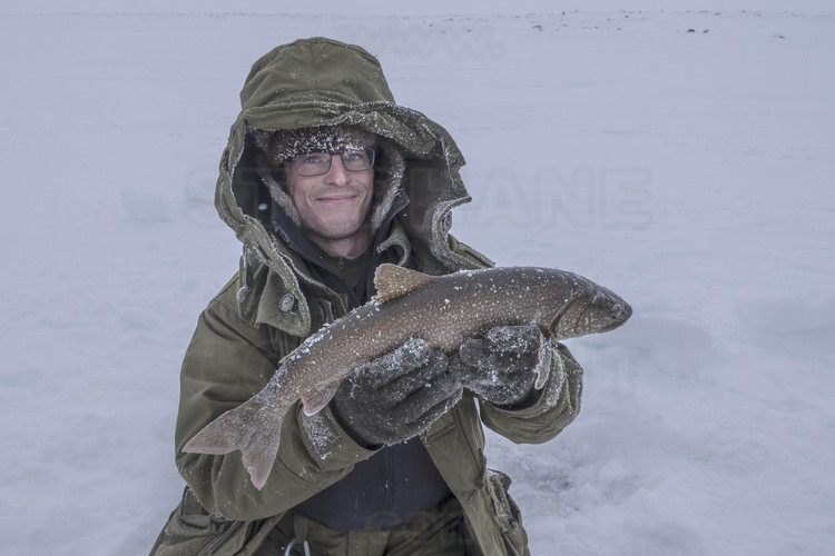 Canada - State of Nunavut - Operation NUNALIVUT 2018 - Surroundings of Cambridge Bay - Survival Camp # 1: Soldiers are initiated by the Rangers into ice fishing, which can save lives in polar isolation. First ice fishing and first success for Corporal Spencer Mc Crae, 26 years old.