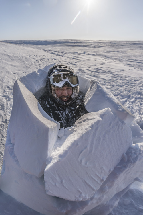 Canada - Etat du Nunavut - Opération Nunalivut 2018 - Environs de Cambridge Bay - Camp de survie n° 2, installé sur une baie du passage du Nord Ouest. Le rangers Tommy Epakolak montre aux militaires comment fabriquer un igloo d'urgence en moins de deux heures. Un savoir faire indispensable en miliieu polaire, où cet abri de fortune peut sauver des vies en cas de problème mécanique ou de météo qui se dégrade subitement (blizzard). // Canada - State of Nunavut - Operation NUNALIVUT 2018 - Surroundings of Cambridge Bay - Survival Camp 2, located on a bay in the Northwest Passage. Rangers Tommy Epakolak shows the military how to make an emergency igloo in less than two hours. Essential know-how in the polar environment, where this makeshift shelter can save lives in the event of a mechanical problem or weather that is suddenly degraded (blizzard).