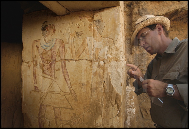 Montant droit de la porte d’entrée de la tombe de Haou-Néfer. Il est représenté (à gauche en rouge) avec son épouse Khouti (à droite en jaune) qui lui apporte des offrandes. Entre son père et sa mère, leur fils aîné. Vassil Dobrev constate qu’un morceau du texte retraçant la carrière du prêtre a été intentionnellement enlevé. Le début du texte est encore visible : « Aimé d’Anubis, aimé d’Osiris, aimé du Roi et de leur Dieu…j’étais un……. » et à partir de là le texte a disparu. Etait-il fait mention d’évènements qui auraient pu se passer au cours du règne « contesté » du prédécesseur de Pépy Ier, le mystérieux roi Ouserkarê ?